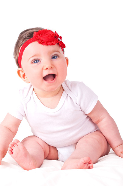 babymeisje met rood lint.  - Foto, afbeelding