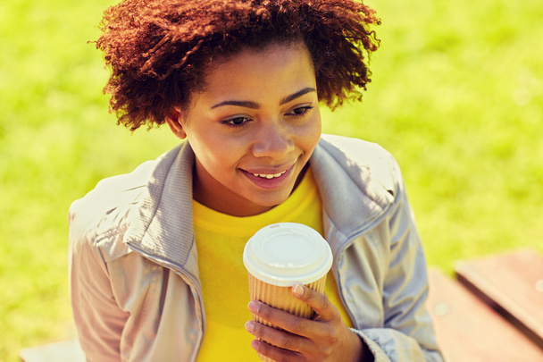 smiling african woman drinking coffee outdoors - Foto, immagini
