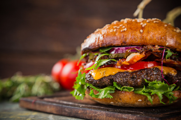 Tasty burgers on wooden table. - Фото, изображение