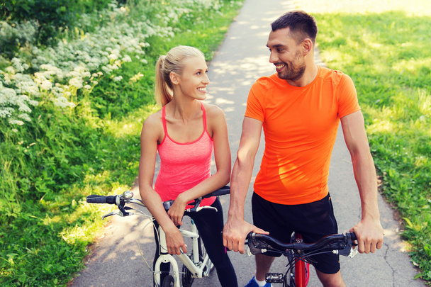 happy couple riding bicycle outdoors - Fotó, kép
