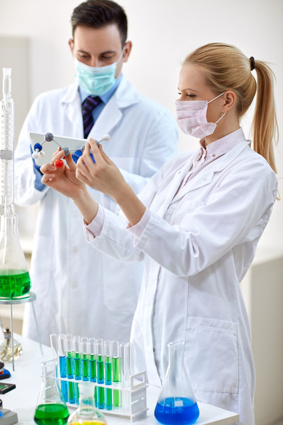 Young female chemist holds molecular mode - Foto, Imagen
