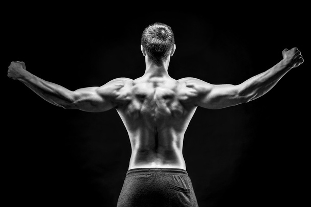 Rear view of muscular young man showing back, biceps muscles - Foto, Bild