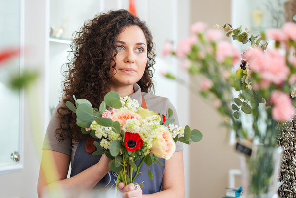 Beautiful young woman florist standing in flower shop - Fotoğraf, Görsel