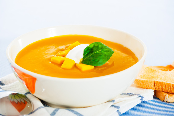 Pumpkin soup with cream in a bowl with painted flower and toast - Photo, Image