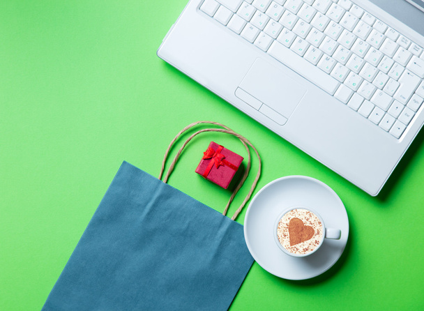 cup, gift, shopping bag and laptop - Foto, imagen