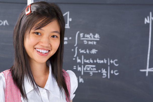 Student pose in front of blackboard - Фото, изображение