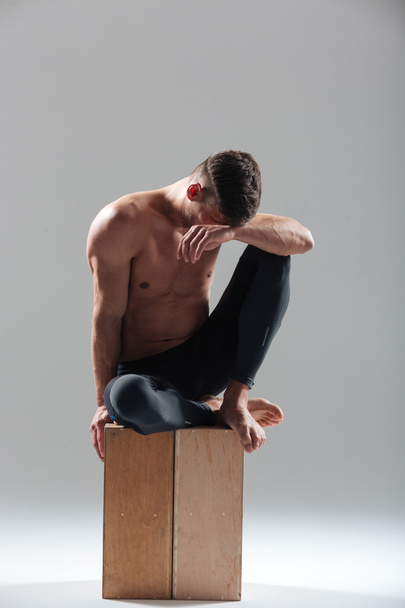 Fitness man resting on wooden box - Фото, изображение