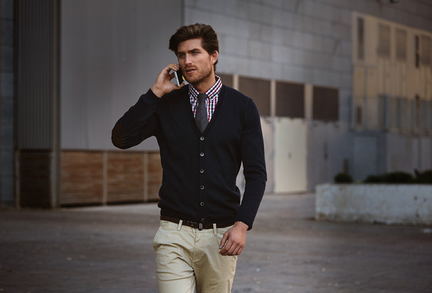 Young businessman talking smartphone walking  - Фото, зображення