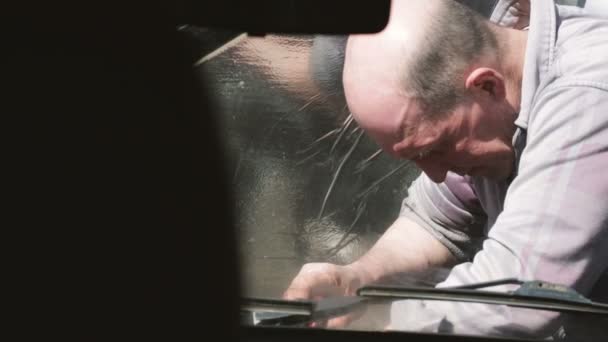 Man of average years repairs the car. - Záběry, video
