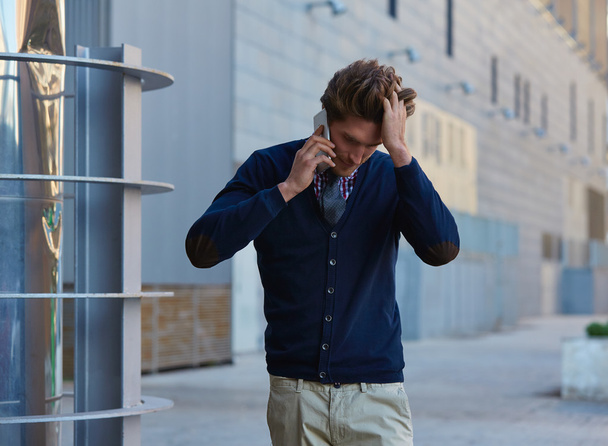 Young businessman talking smartphone walking  - Foto, afbeelding