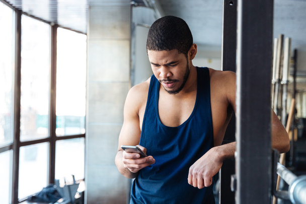 Fitness man using smart phone in the gym - Фото, зображення