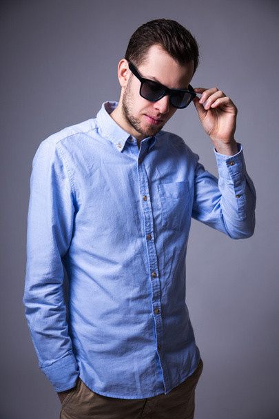 Porträt des jungen Mann mit Sonnenbrille in grau - Foto, Bild