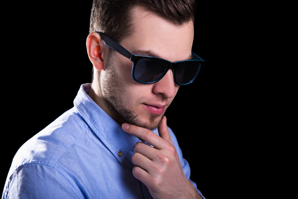 jonge knappe man in zonnebril denken over iets over b - Foto, afbeelding