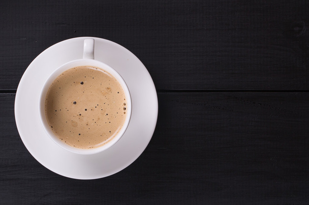 Cappuccino z cynamonu w filiżance biały. Kawa na czarny drewniany stół - Zdjęcie, obraz