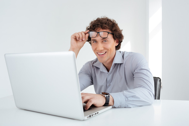 Smiling businessman working on laptop computer - Valokuva, kuva