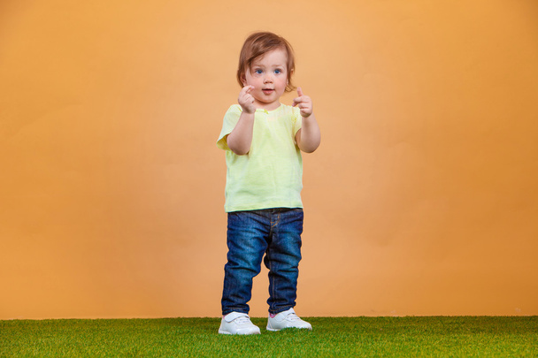One cute baby girl on orange background - Valokuva, kuva