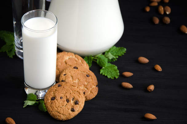 glass of milk cookies almonds mint - Foto, afbeelding