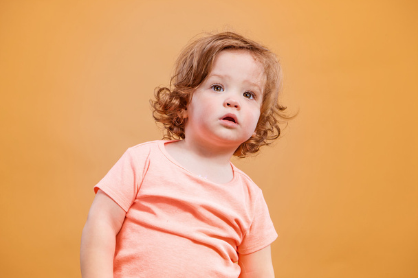 One cute baby girl on orange background - Zdjęcie, obraz