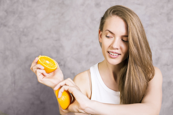 Charming woman holding oranges - Foto, imagen