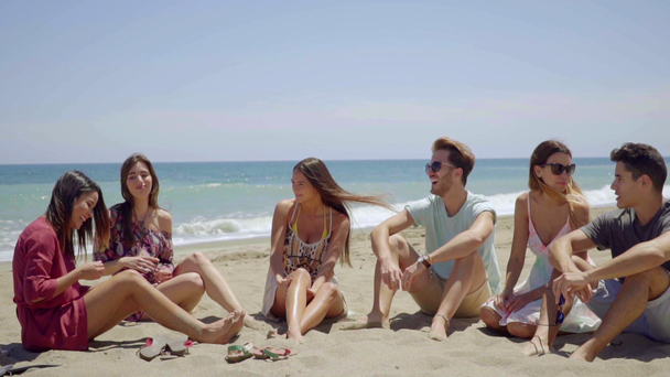 ludzie siedzą na piasku i rozmawiać ze sobą - Materiał filmowy, wideo