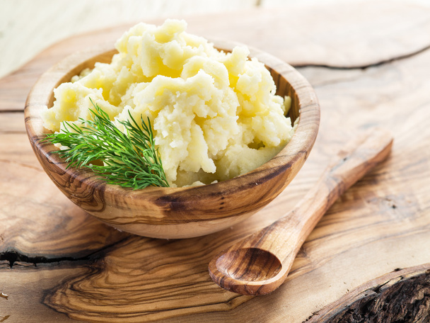 Mashed potatoes in the wooden bowl on the service tray. - Photo, image