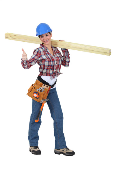 Woman carrying two planks of wood - Фото, изображение