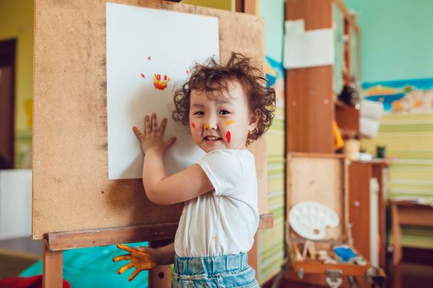 The girl draws a painting at the easel - 写真・画像