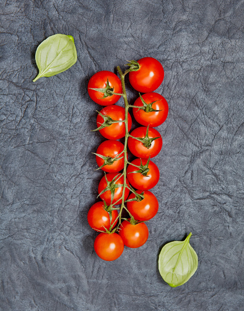 Tomatoes,  basil  on a dark  background. - Foto, imagen