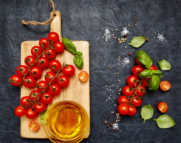 Tomatoes, basil and oil on a board. - Foto, imagen