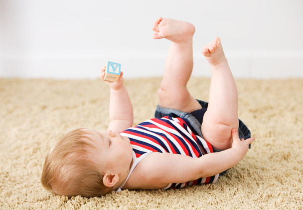 Baby: Little Girl Plays With Toy Wooden Blocks On Carpet - Foto, imagen