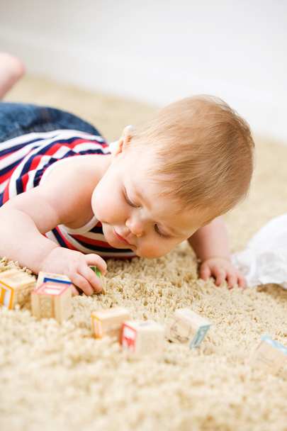 Baby: Little Girl Plays With Toy Wooden Blocks On Carpet - Zdjęcie, obraz