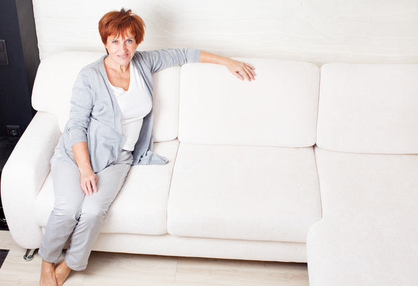 Mulher madura feliz no sofá
 - Foto, Imagem