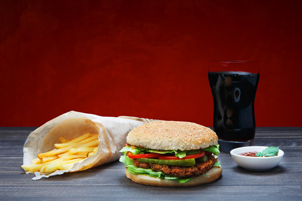 A comida rápida leva-nos. Hambúrguer, cola e batatas fritas
. - Foto, Imagem