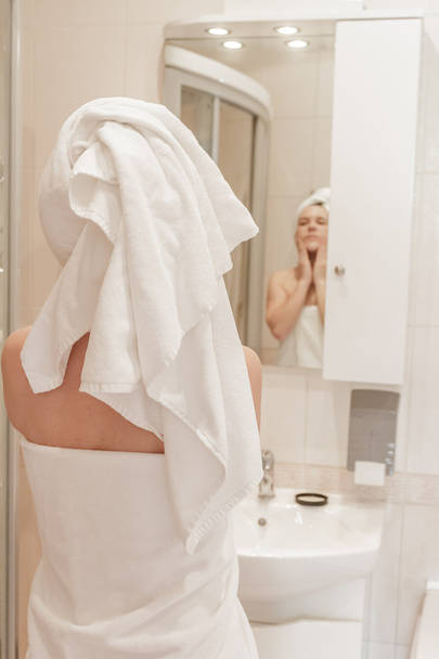 красива жінка наносить крем на обличчя у ванній
 - Фото, зображення