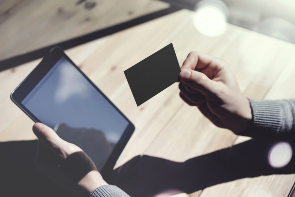 Photo Man Showing Blank Black Business Card and Holding Hand Modern Digital Tablet Blurred Background. Mockup Ready for Private Information. Sunlight Reflections Screen Gadget. Horizontal mock up. - Foto, afbeelding