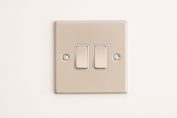 Doble interruptor de luz en una pared blanca
 - Foto, imagen