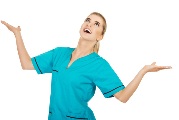 Mladý úsměv žena lékař nebo zdravotní sestra úlovky něco ze vzduchu - Fotografie, Obrázek