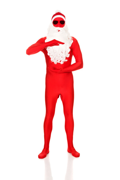 Santa in latex clothing holding copyspace - Foto, imagen