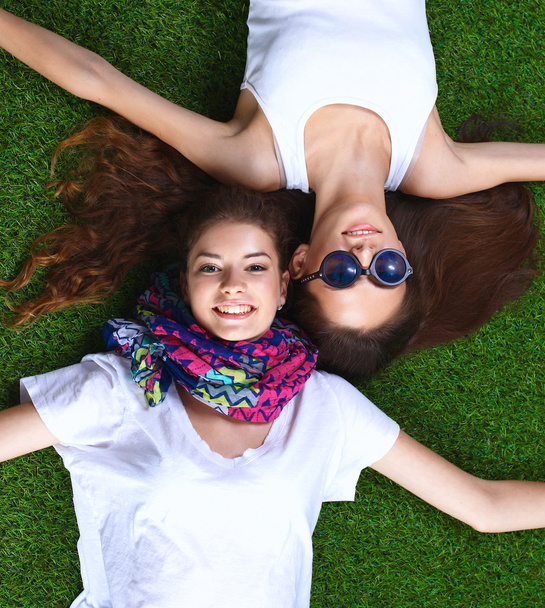 Attractive young girls relaxing on grass. - Fotografie, Obrázek