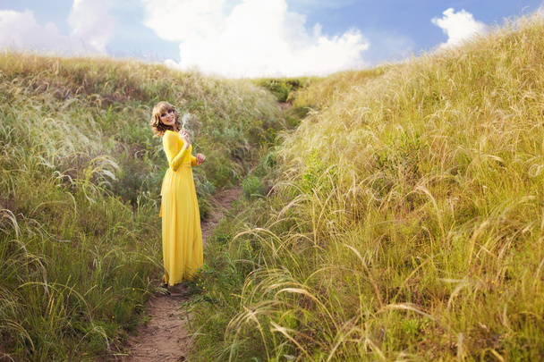 Retrato al aire libre de una mujer hermosa. Chica atractiva en el prado de hierba de plumas
 - Foto, Imagen