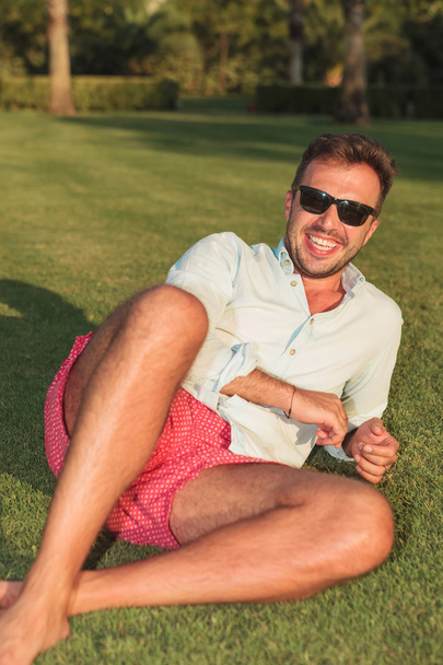 mladí causual muž ležící v trávě a směje se - Fotografie, Obrázek