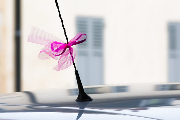 Decoración de cinta de boda en una antena de coche
 - Foto, imagen