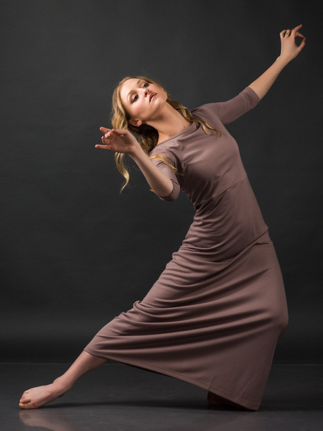 Dançarina. Dança contemporânea. Bela mulher elegante dança no fundo cinza
 - Foto, Imagem