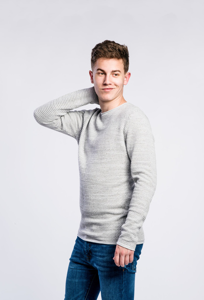 Boy in jeans and sweater, young man, studio shot - Foto, imagen