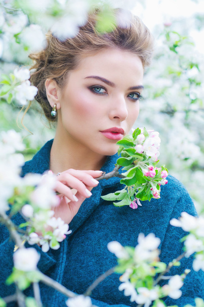 Nainen kukkivassa kevätpuutarhassa
 - Valokuva, kuva