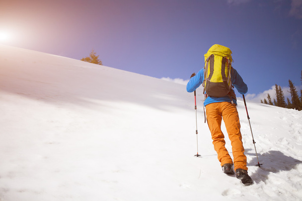Bergsteiger mit Rucksack erklimmt den Schnee. - Foto, Bild