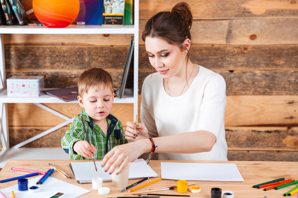 Beautiful mother and her little son painting in art school - Foto, imagen