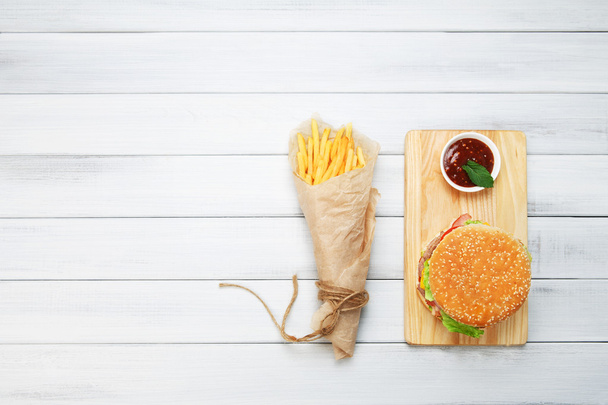 Burger, chips and ketchup at white wood - Fotoğraf, Görsel