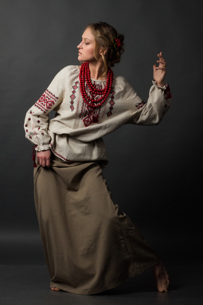 Danser. Mooie gelukkig leuke jonge vrouw in Oekraïense borduurwerk dansen  - Foto, afbeelding