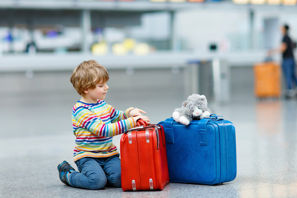 Kleiner Junge mit Koffern auf internationalem Flughafen - Foto, Bild